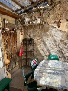 a table and chairs in a room with a stone wall at Casa Rural Neveritas in Piedrahita