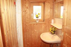 a bathroom with a sink and a vase of flowers on a window at Ferienhaus Talblick in Weiler-Simmerberg +26 photos