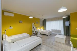 salon z 2 białymi kanapami i żółtą ścianą w obiekcie Opera Passage Hotel & Apartments w Lwowie