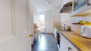 a kitchen with white cabinets and a wooden counter top at The Bardwell in Oxford