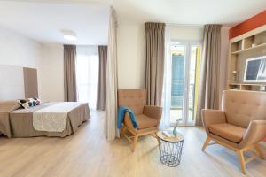 a hotel room with a bed and two chairs at Appart One Fréjus in Fréjus