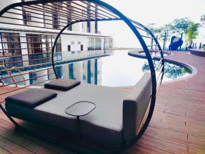 a bed sitting on a deck next to a pool at Cozy Ocean View APT in KK City Center in Kota Kinabalu