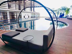 哥打京那巴鲁Cozy Ocean View APT in KK City Center的游泳池畔甲板上的一张床
