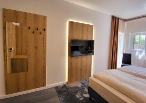 a bedroom with a bed and a door with a television at Villa Bauhaus Wellness Apart-Hotel in Siófok