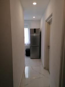 a kitchen with a refrigerator in the middle of a hallway at Borsalino Apartman in Veszprém