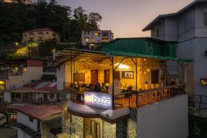 un restaurante con un cartel en el balcón de un edificio en ArtBuzz Mussoorie, en Mussoorie