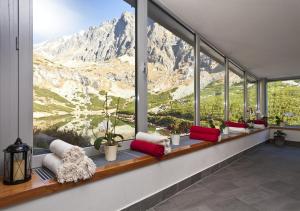 a room with a large window with a view of the mountains at Horsky Hotel Sliezsky Dom in Vysoké Tatry
