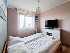 a bedroom with two beds and a flat screen tv at Wicher Hel - mieszkanie blisko centrum in Hel