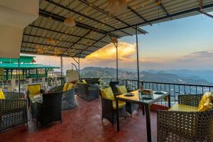 a restaurant with a table and chairs on a balcony at ArtBuzz Mussoorie in Mussoorie