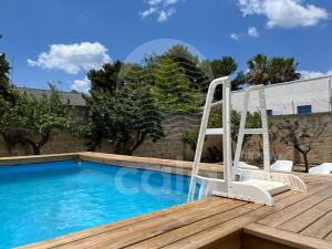 een zwembad met een glijbaan en stoelen op een terras bij Villa Capitano - piscina privata By Cala Salento in Torre Lapillo