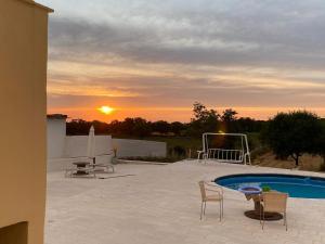 - un coucher de soleil sur une terrasse avec une piscine et des chaises dans l'établissement Casa Loredana, à Putignano