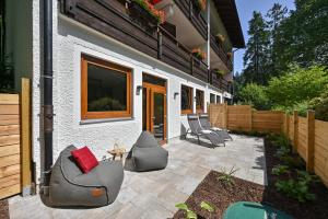 un patio con tumbonas y una casa en Hotel Ruchti - Zeit für mich en Füssen