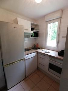une cuisine avec un réfrigérateur blanc et une fenêtre dans l'établissement Détent'Appart Proche Quais, à Canteleu