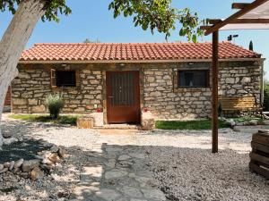 una casa de piedra con techo rojo en Villa Nikos, en Cefalonia