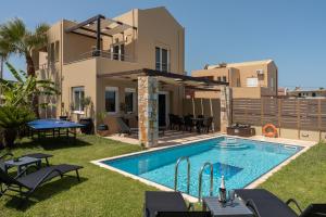 a backyard with a swimming pool and a house at Villa Per Mare in Maleme