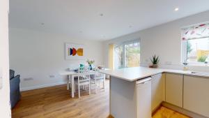 a kitchen with white counters and a table with chairs at Park View in Oxford