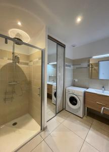 een badkamer met een wasmachine en een wasmachine bij Val des Bruyères - gîte 15mn Pézenas avec terrasse et cour close - Parking privatif securisé - Wifi gratuit in Néffiès