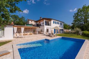 une villa avec une piscine en face d'une maison dans l'établissement Lavova, à Brtonigla
