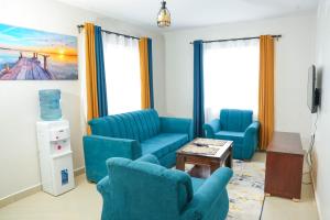 Una sala de estar con sillas azules y una mesa. en Shalom Studio city Apartments., en Naivasha