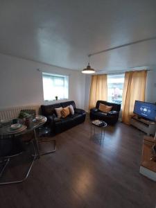 a living room with a couch and a tv at Toni's Hub - 2 bed City Centre Apartment in Derby