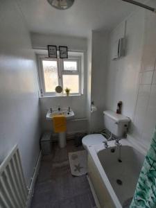 a bathroom with a tub and a toilet and a sink at Toni's Hub - 2 bed City Centre Apartment in Derby