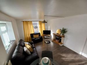 a living room with a leather couch and a television at Toni's Hub - 2 bed City Centre Apartment in Derby