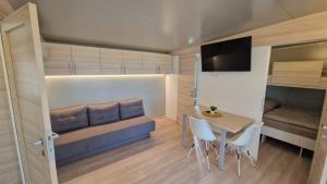 a small room with a bed and a table and chairs at Mobile Home Drage in Drage