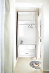 Un armario con gabinetes blancos y una alfombra. en Shalom Studio city Apartments., en Naivasha