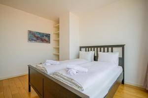 una camera da letto con un grande letto bianco con asciugamani di Luxury Apartment with balcony in Downtown a Budapest