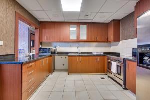 a large kitchen with wooden cabinets and appliances at Amazing Sea View apartment in the JBR in Dubai