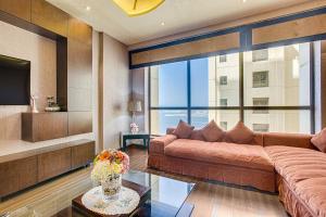 a living room with a couch and a large window at Amazing Sea View apartment in the JBR in Dubai