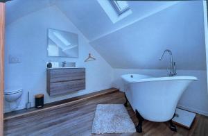 La salle de bains est pourvue d'une baignoire blanche et de toilettes. dans l'établissement Wellness Loft Huy, à Huy