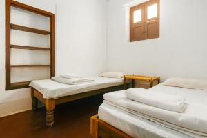 a room with three beds and a window at Laika Heritage Stay in Mysore