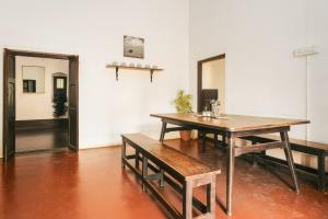 ein Esszimmer mit einem Tisch und Bänken in einem Zimmer in der Unterkunft Laika Heritage Stay in Mysore