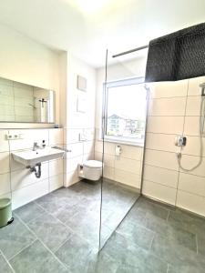 a bathroom with a shower and a sink and a toilet at Ferienwohnungen Alpenliebe & Auszeit in Sonthofen