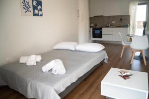 a bedroom with a bed with towels on it at Naiads Nest - The Comfort Lux in Varkiza