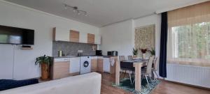a kitchen and a living room with a table and a couch at City Center apartman in Siófok