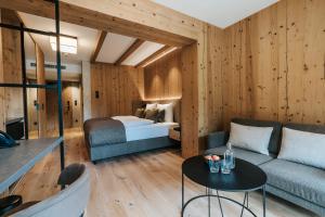 a bedroom with a bed and a couch and a table at NOVA Moments Boutique Hotel in Pertisau
