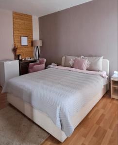 ein Schlafzimmer mit einem großen weißen Bett mit rosa Kissen in der Unterkunft Hotel Park in Negotino