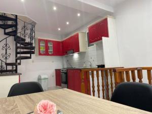 eine Küche mit roten Schränken und einem Tisch mit Stühlen in der Unterkunft Home Away Junior Suite. in Zakynthos