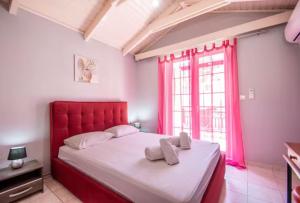 ein Schlafzimmer mit einem roten Bett und einem Fenster in der Unterkunft Home Away Junior Suite. in Zakynthos