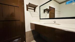 uma casa de banho com um lavatório e um espelho em TC Garden Resort em Kuah