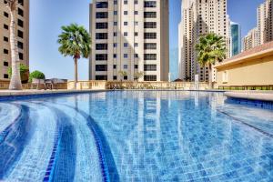 a large swimming pool in a city with tall buildings at Amazing Sea View apartment in the JBR in Dubai