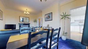 a dining room and living room with a table and chairs at Portland Street Apartment in Leamington Spa