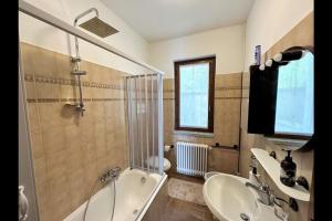 uma casa de banho com uma banheira e um lavatório e uma banheira em Katty House - Dizzasco Lake Como em Muronico
