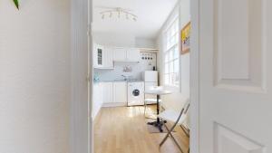 a kitchen with white cabinets and a table at Portland Street Apartment in Leamington Spa