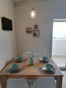 a dining room table with chairs and a wooden table with plates at Panoramic view in Preveza +16 photos