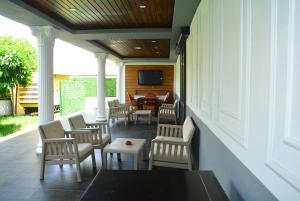 une terrasse couverte avec des chaises, une table et une télévision dans l'établissement Rafael Hotel, à Manavgat