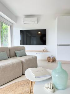 ein Wohnzimmer mit Couch und Tisch in der Unterkunft Le Soleil d’or in Théoule-sur-Mer