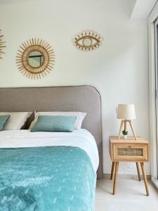 ein Schlafzimmer mit einem Bett und einem Spiegel an der Wand in der Unterkunft Le Soleil d’or in Théoule-sur-Mer